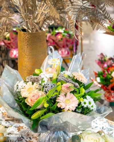 Bouquet de fleurs avec roses et gerberas, fond de décorations festives.